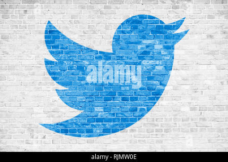 BERLIN, GERMANY - JAN 20 2019: Twitter social media blue bird sign symbol in minimalist design painted over white brick wall background. Concept for t Stock Photo