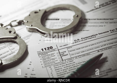tax evasion concept - tax form 1120 and handcuffs Stock Photo