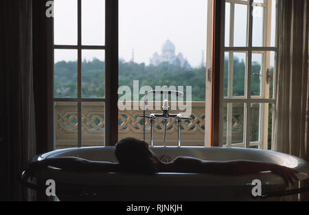 Caption: Agra, Rajasthan, India - Apr 2003. A guest is relaxing in a bath overlooking the Taj Mahal, inside one of the spa suites at the Banyan tree s Stock Photo