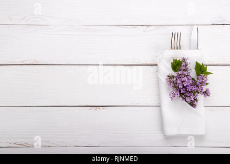 Spring festive table setting with vintage cutlery and lilac flowers on white wooden table,copy space flat lay Stock Photo