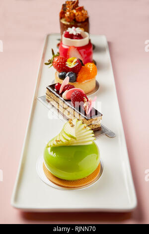 Mini cakes selection with apple cake, fruit tart, and two chocolate cakes Stock Photo