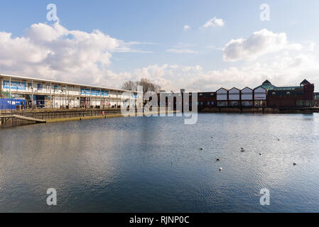 View of Decathlon Sports Centre and Surrey Quays Shopping Centre across the pond in Canada Water on a sunny day. London, England.