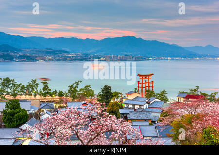 Miyajima Island, Hiroshima, Japan with temples on the Seto Inland Sea at dusk in the spring season. Stock Photo