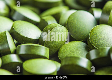 Chlorella or green barley. Detox superfood. Spirulina pills. Stock Photo