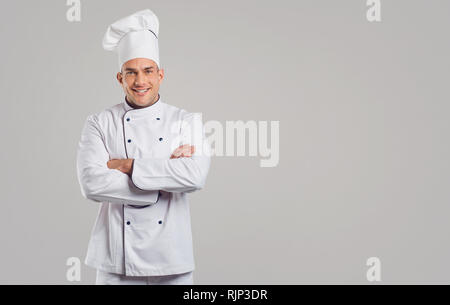 Cook in white uniform is smiling. Stock Photo