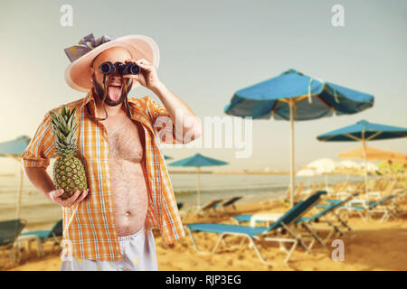 Funny fat bearded man with binoculars on vacation in  the beach in summer.  Stock Photo
