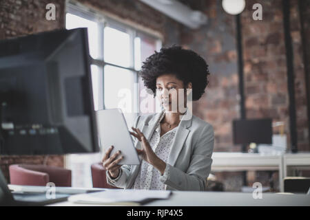 Female african american business executive working in an office on a digital tablet Stock Photo