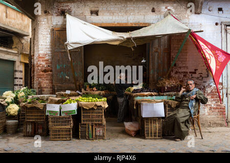 Local buyers in a grocery shop at Rasheed (Egypt) souq marketplace selling cauliflowers, eggplants and other produce. Stock Photo