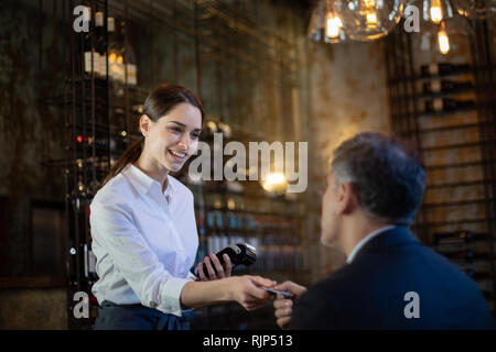 Waitress taking payment in a restaurant Stock Photo