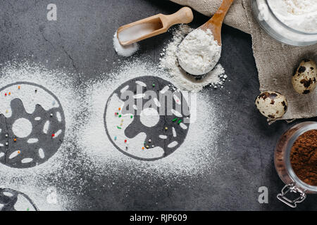 Ingredients for donuts baking. Spoon with flour, dishes, eggs, sugar on a grey background. Top view, copy space. Bakery background frame. Stock Photo