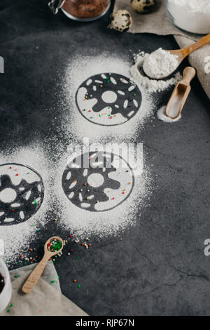 Ingredients for donuts baking. Spoon with flour, dishes, eggs, sugar on a grey background. Top view, copy space. Bakery background frame. Stock Photo