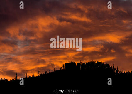 An apocalyptic sunset over the hilltops at Queen Charlotte along the Inside Passage Stock Photo