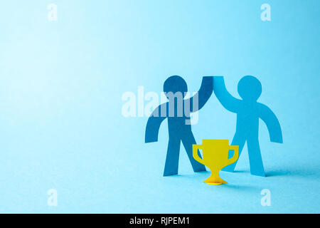 Successful business team winner holds gold cup in his hands. Team building. Leader and Workers Reach the Goal. Copy space for text. Stock Photo