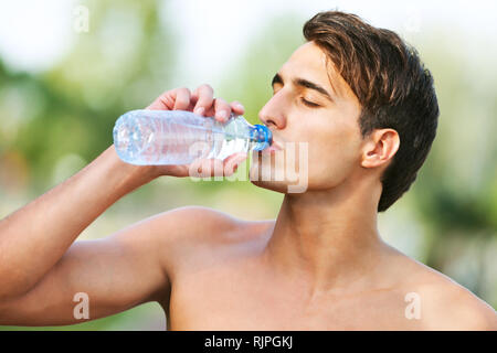 Young man drinking water after jogging Stock Photo