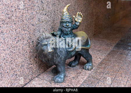 One of the brass gnomes (krasnale, krasnoludki) riding a lion, in Wrocław, Wroklaw, Poland Stock Photo