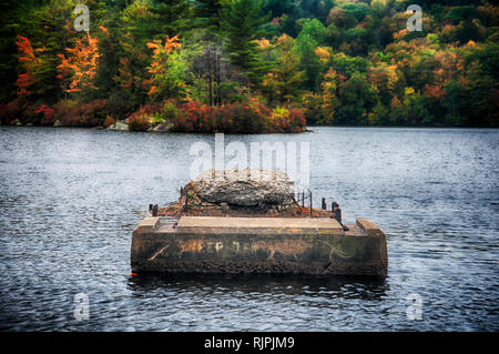 The green and changing colors trees reflecting off of the waters in Burr State Park in Torrington, Connecticut on a sunny fall day. Stock Photo