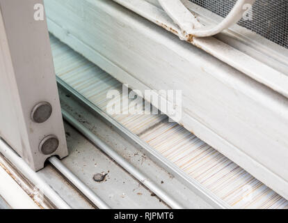 Sliding glass door on the dirty stainless rail of the urban house. Stock Photo