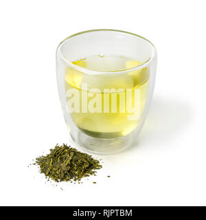 Glass cup of Japanese green tea and a heap of dried green tea leaves isolated on white background Stock Photo