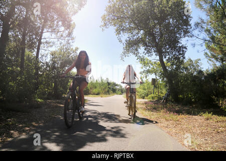 Teenagers cycling on countryside road, Aquitaine, France Stock Photo