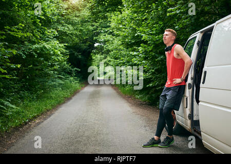 Runner leaning on van Stock Photo