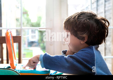 Toddler boy using toy laptop Stock Photo