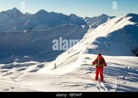 Male ski tourer enjoying the view on a summit in the alps Stock Photo