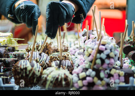 Sweet candy in chocolate on a stick. Sweets for children. Apples in chocolate on a stick. Sweet dessert. Stock Photo