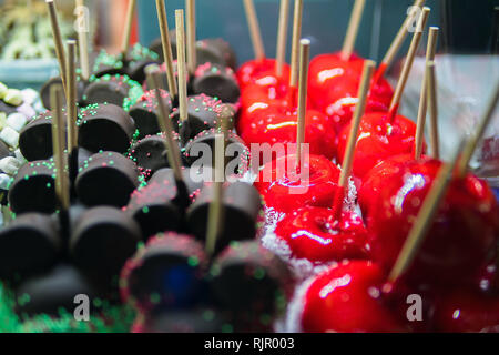 Sweet candy in chocolate on a stick. Sweets for children. Apples in chocolate on a stick. Sweet dessert. Stock Photo