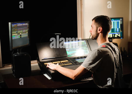 A lighting engineer works with lights technicians control Stock Photo