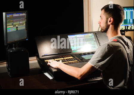 A lighting engineer works with lights technicians control Stock Photo