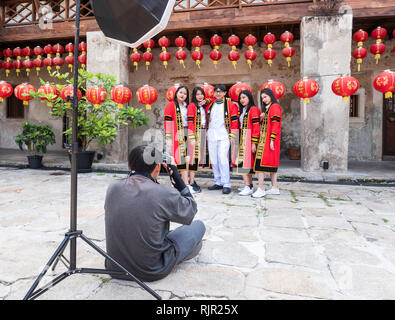 Photographer taking photos of students wearing graduation gowns at Lhong 1919, a 19th century Chinese mansion on the west bank of Chayo Praya River in Stock Photo