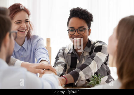 Happy african and caucasian people stacking hands, team support concept Stock Photo