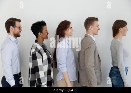 Side view at happy diverse business people standing in queue Stock Photo