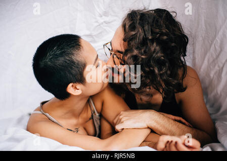 Happy couple under covers in bed Stock Photo