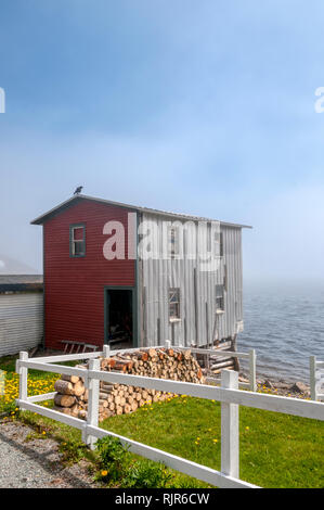 A workshop on the shores of Trinity Bay on the Bonavista Peninsula in Newfoundland, with fog drifting off the sea. Stock Photo