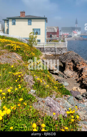 Fog drifting off of Trinity Bay over the town of Trinity on the Bonavista Peninsula in Newfoundland Stock Photo