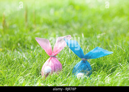 Two Easter eggs in the form of Easter rabbits made of paper, hiding in the grass Stock Photo