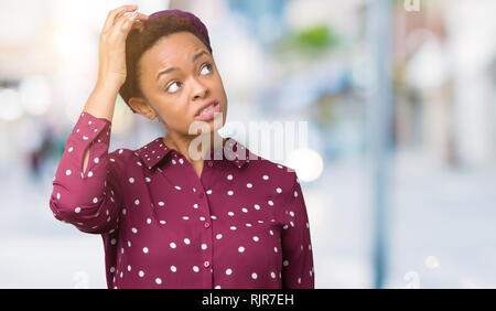 Beautiful young african american woman wearing head scarf over isolated background confuse and wonder about question. Uncertain with doubt, thinking w Stock Photo
