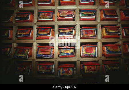 Caption: Pelling, Sikkim, India - Sep 1999. Tibetan Buddhist texts lined up in special boxes in Tashiding monastery. The texts are available to monks  Stock Photo
