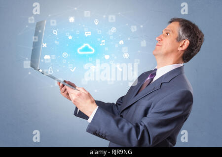 Man holding laptop projecting notifications, symbols and information based on cloud technology system  Stock Photo