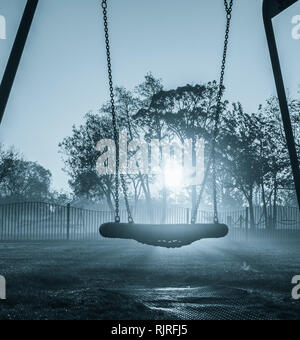 Swings in public park on a misty morning. UK Stock Photo