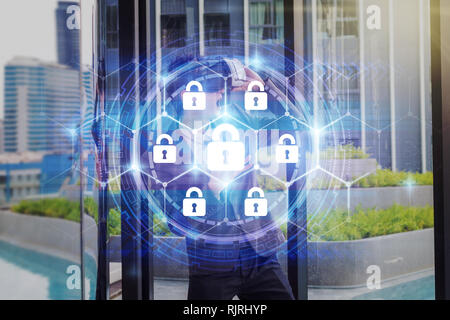 Asian Man wearing virtual reality with business suit at modern building over the Security key lock icon digital display over world map and Hexagon sha Stock Photo