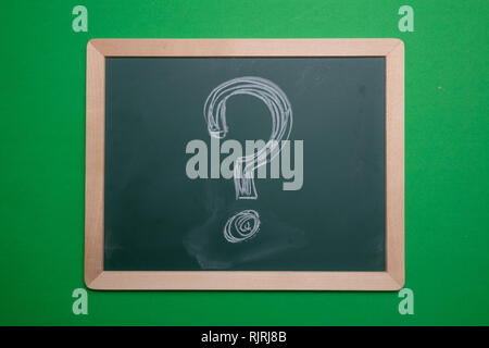 Question mark. Chalk hand drawing question mark shape on green board with wooden frame background Stock Photo