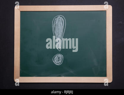 Exclamation mark, warning, attention. Chalk hand drawing exclamation mark shape on green board with wooden frame background Stock Photo
