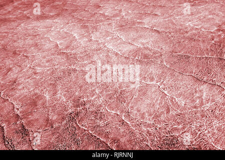 Empty abstract background naturally created by small sea waves in shallow waters and sunlight reflections on water surface. Toned in blend of live cor Stock Photo