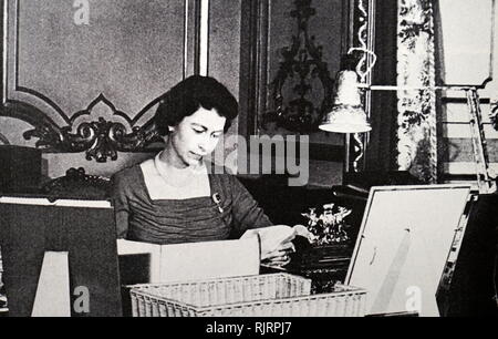 Young Queen Elizabeth II of Great Britain reading despatch papers from her Red Box. Circa 1956 Stock Photo