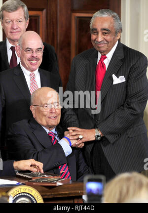 March 23, 2010 - Washington, District of Columbia, U.S. - Washington, DC - March 23, 2010 -- United States Representative Charlie Rangel (Democrat of New York), right, shakes hands with U.S. Representative John Dingell (Democrat of Michigan), lower left, as U.S. President Barack Obama (not pictured) signs the version of the health care bill that was passed by the U.S. House of Representatives in the East Room of the White House in Washington, DC on Tuesday, March 23, 2010. U.S. Senator Max Baucus (Democrat of Montana), upper left, and U.S. Representative Henry Waxman (Democrat of Californ Stock Photo
