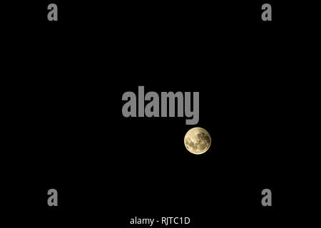 Full moon during an eclipse. Moon covered by the gloom of the earth. Red moon over the dark sky. Stock Photo