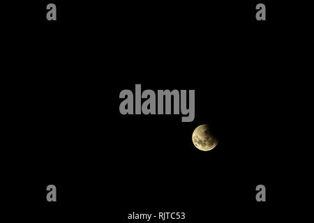 Full moon during an eclipse. Moon covered by the gloom of the earth. Red moon over the dark sky. Stock Photo