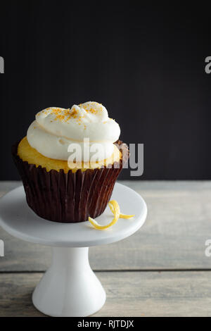 Lemon Cupcake on Cake Stand on Wooden and Black Background Stock Photo
